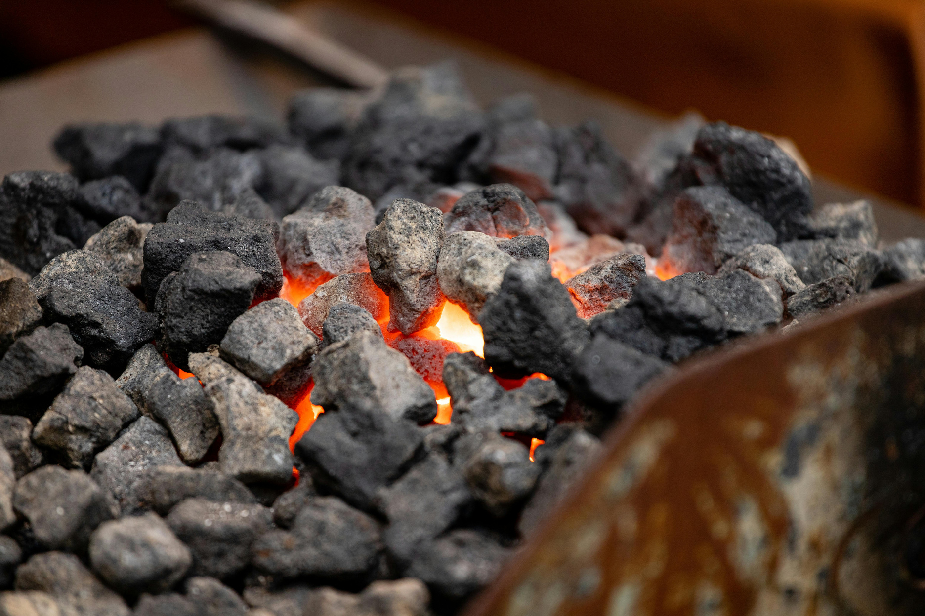 Glowing industrial coals in a forge representing energy-grade fuels supplied by Lumara Corporation